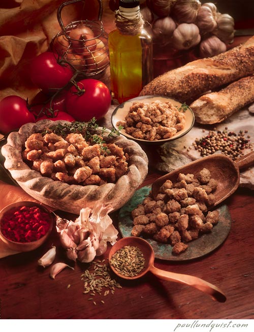 Bowls and scoop of spiced sausage with olive oil, garlic, onions, tomatos, herbs and french bread baguettes. Hormel.